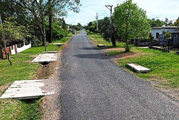 Calle con tratamiento bituminoso, cunetas y pasos de hormigón